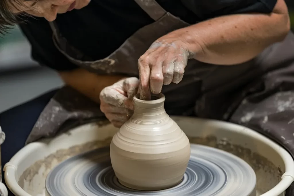 a girl making a clay vase